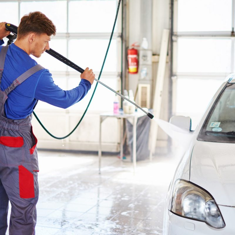 Man worker washing car on a car wash.